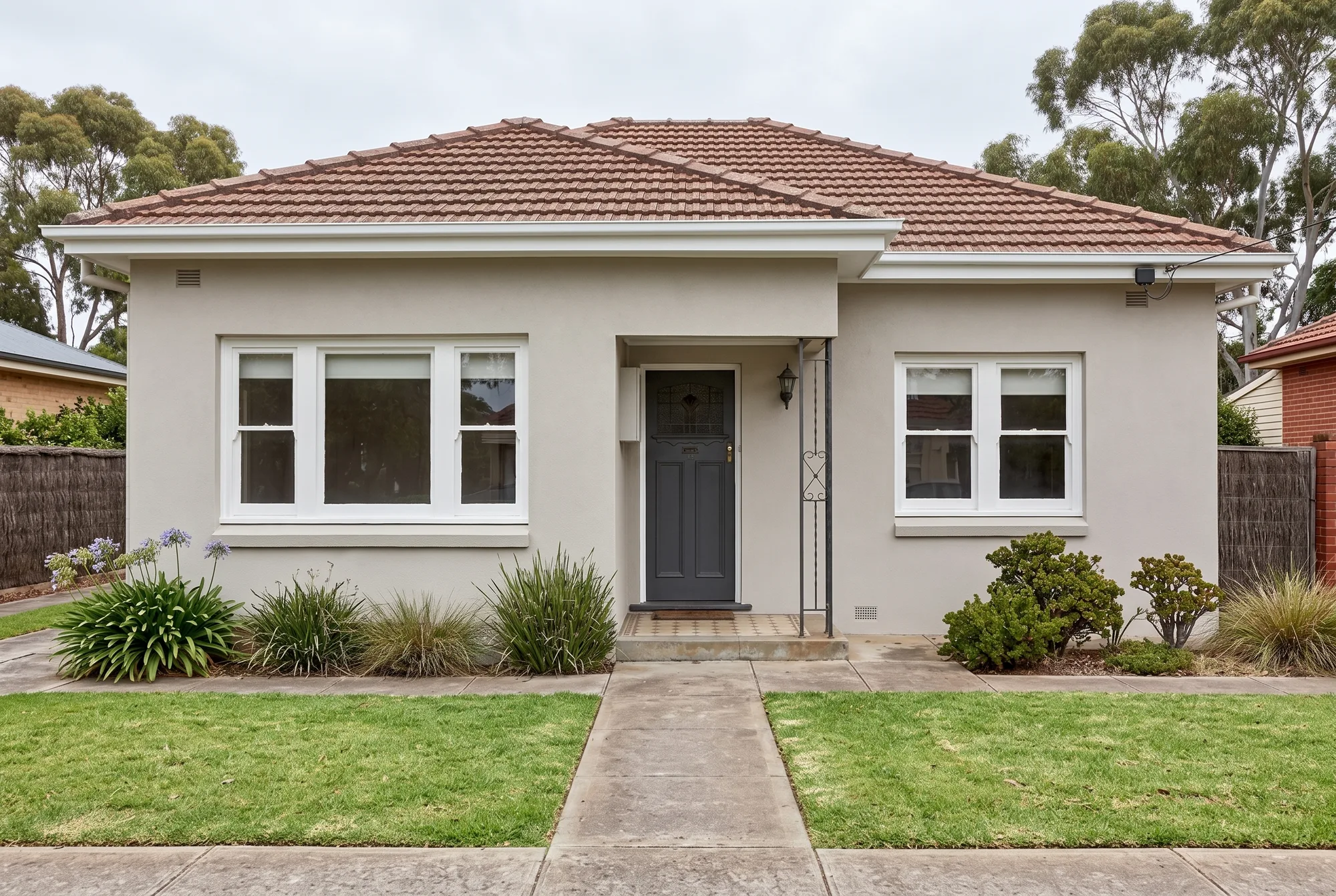 The same rendered house facade freshly painted in warm light grey with white trims and a charcoal front door