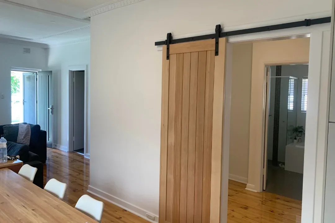 Hallway painted white with a sliding timber barn door