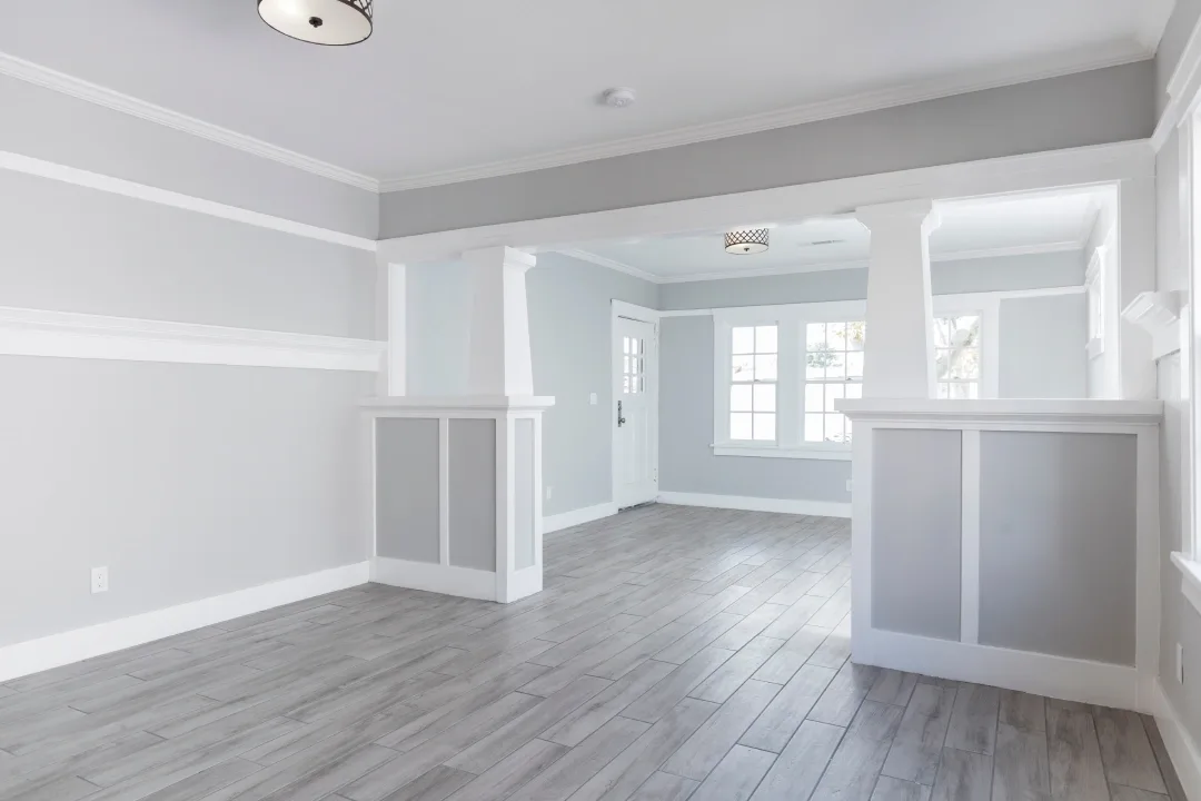 Open-plan living area freshly painted in white with a timber floor
