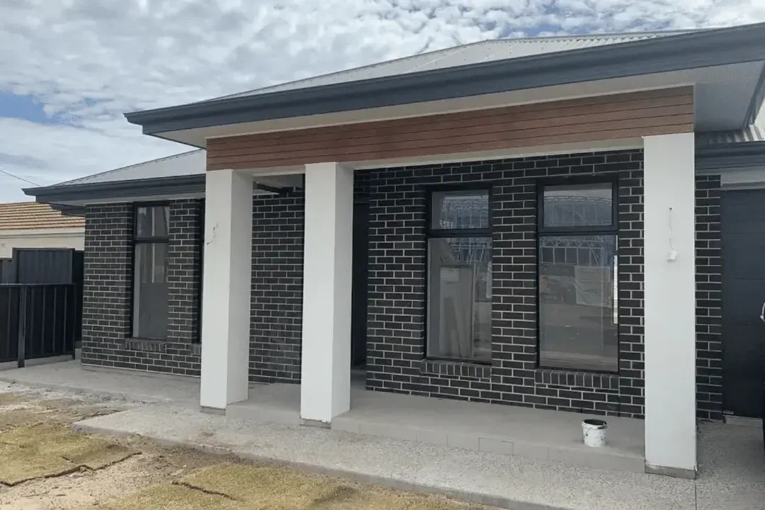 Modern dark brick home exterior with crisp white window and door trims