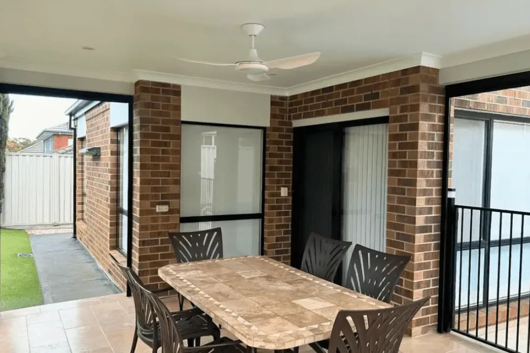 Outdoor entertaining area with painted brick and white timber beams