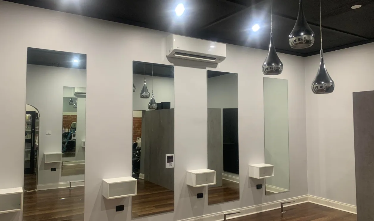 Hair salon interior with white walls and a row of mirrors