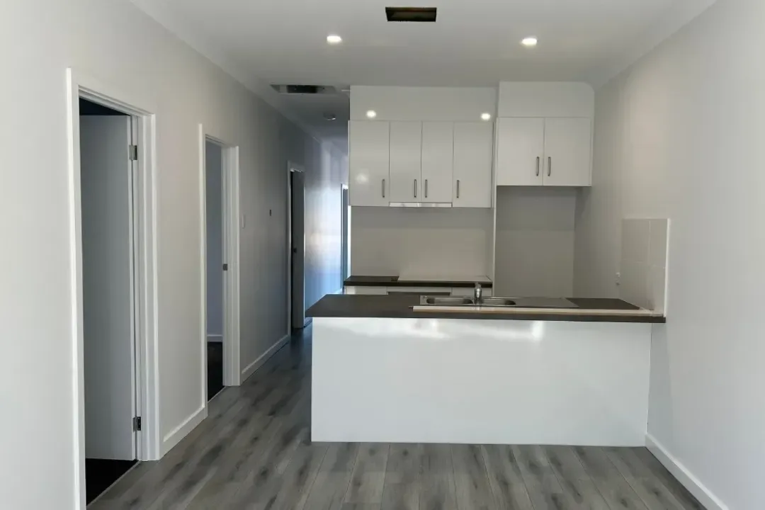 Kitchen freshly painted in white with matching cabinetry and trims